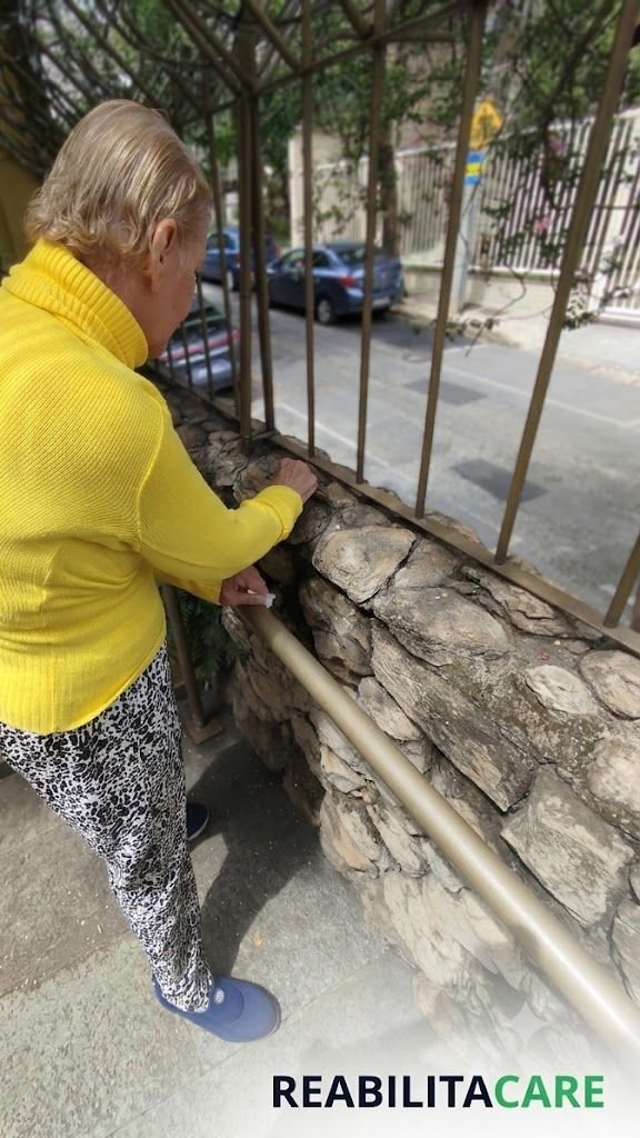 Paciente idosa em pé na varanda de casa