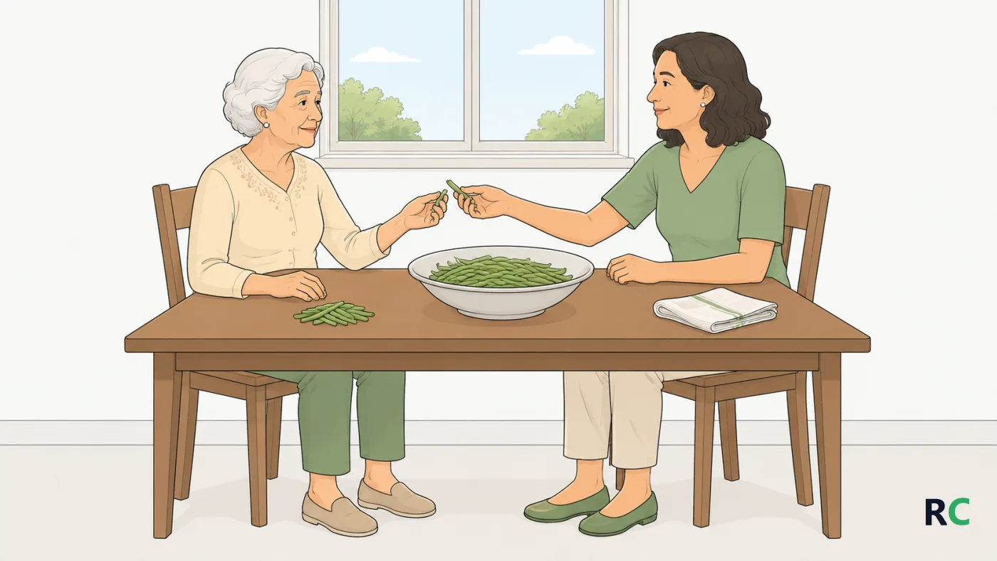 Ilustração de filha e mãe idosa sentadas lado a lado à mesa da cozinha, a filha entregando à mãe uma vagem já começada para debulhar, com a bacia entre as duas